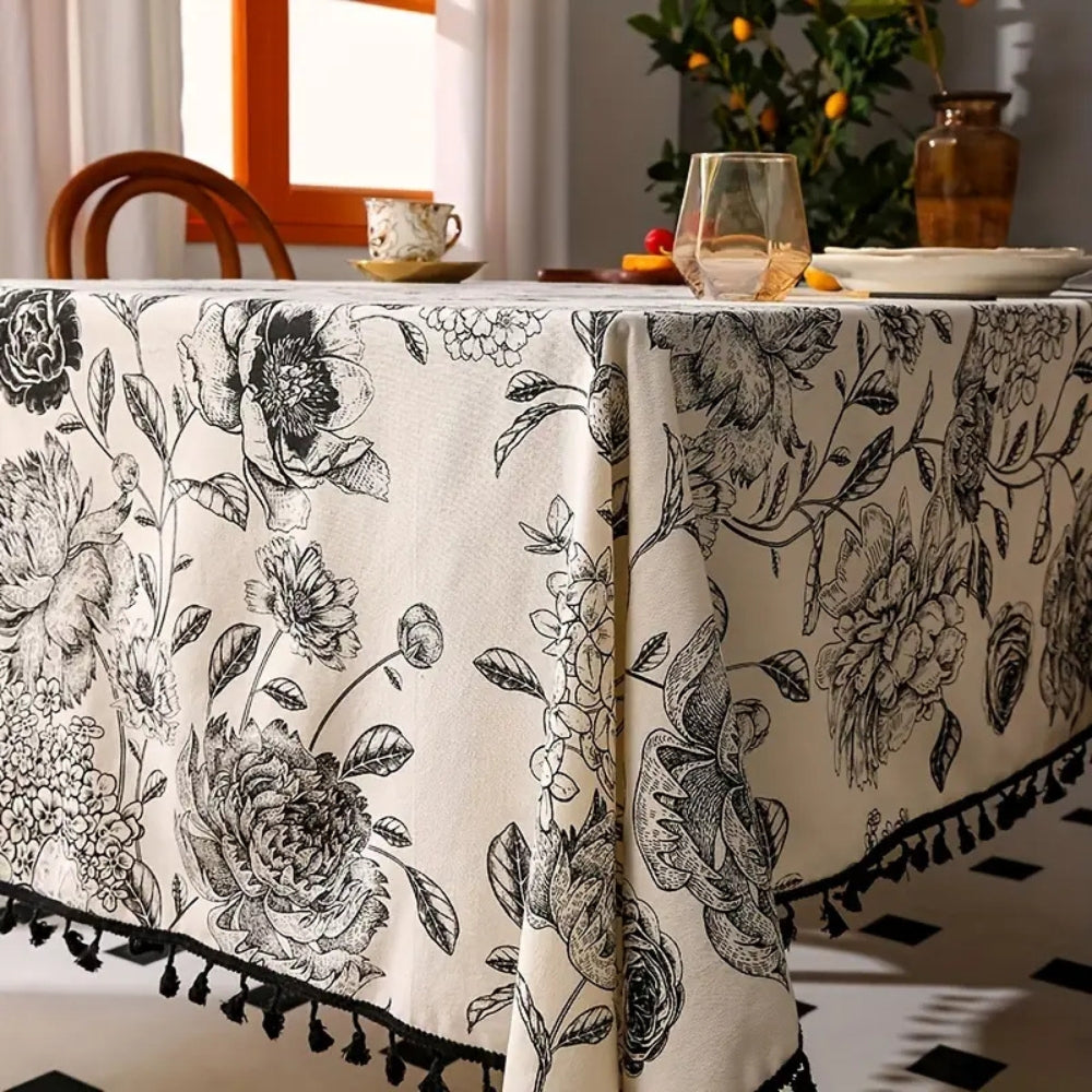Black floral tasseled farmhouse tablecloth with intricate embroidery and a rustic charm.