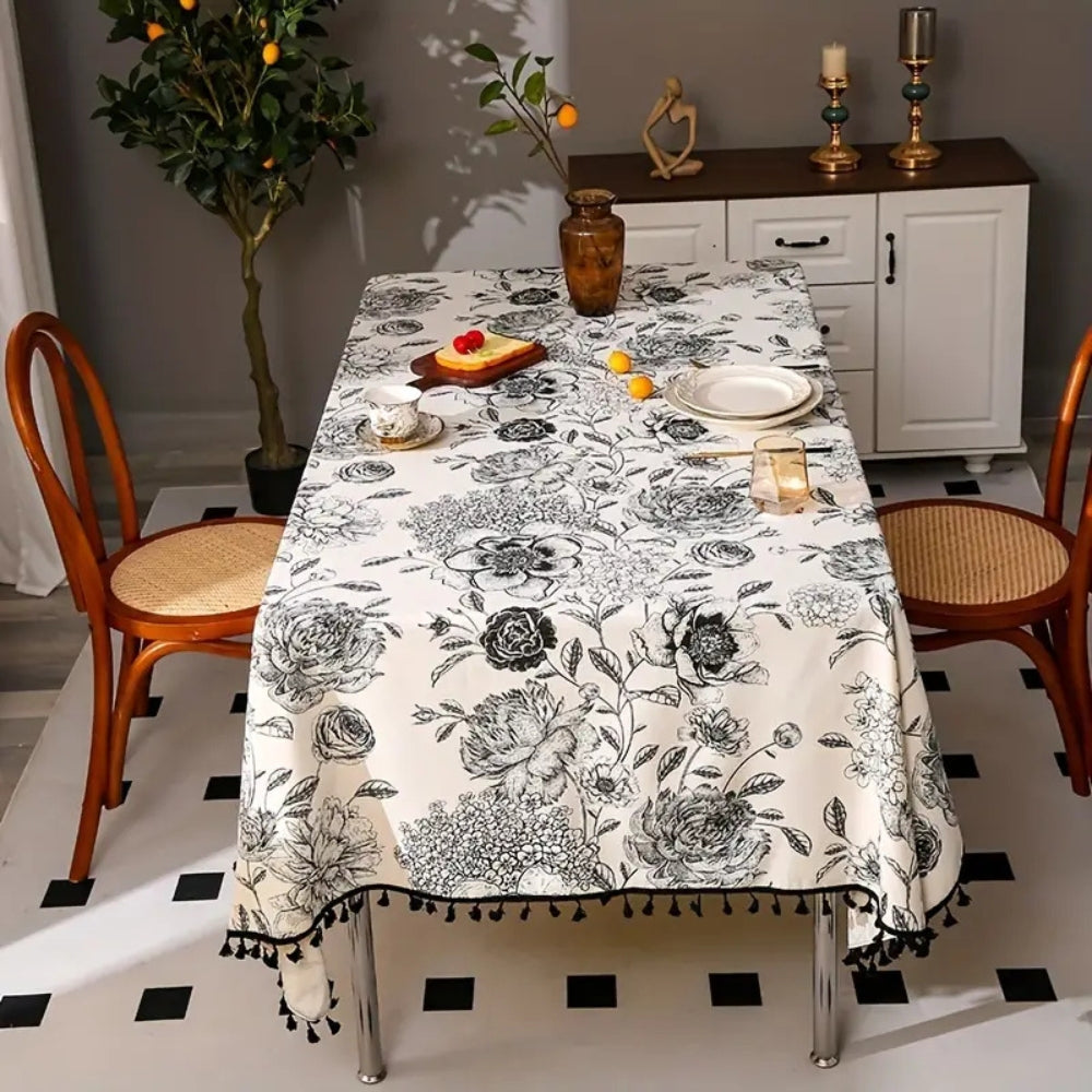 Close-up view of black floral tasseled farmhouse tablecloth with delicate stitching and a vintage vibe.