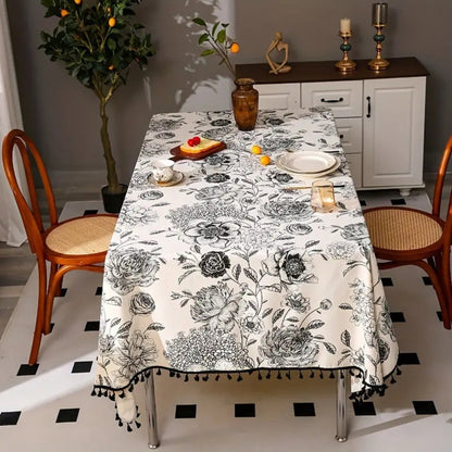 Close-up view of black floral tasseled farmhouse tablecloth with delicate stitching and a vintage vibe.