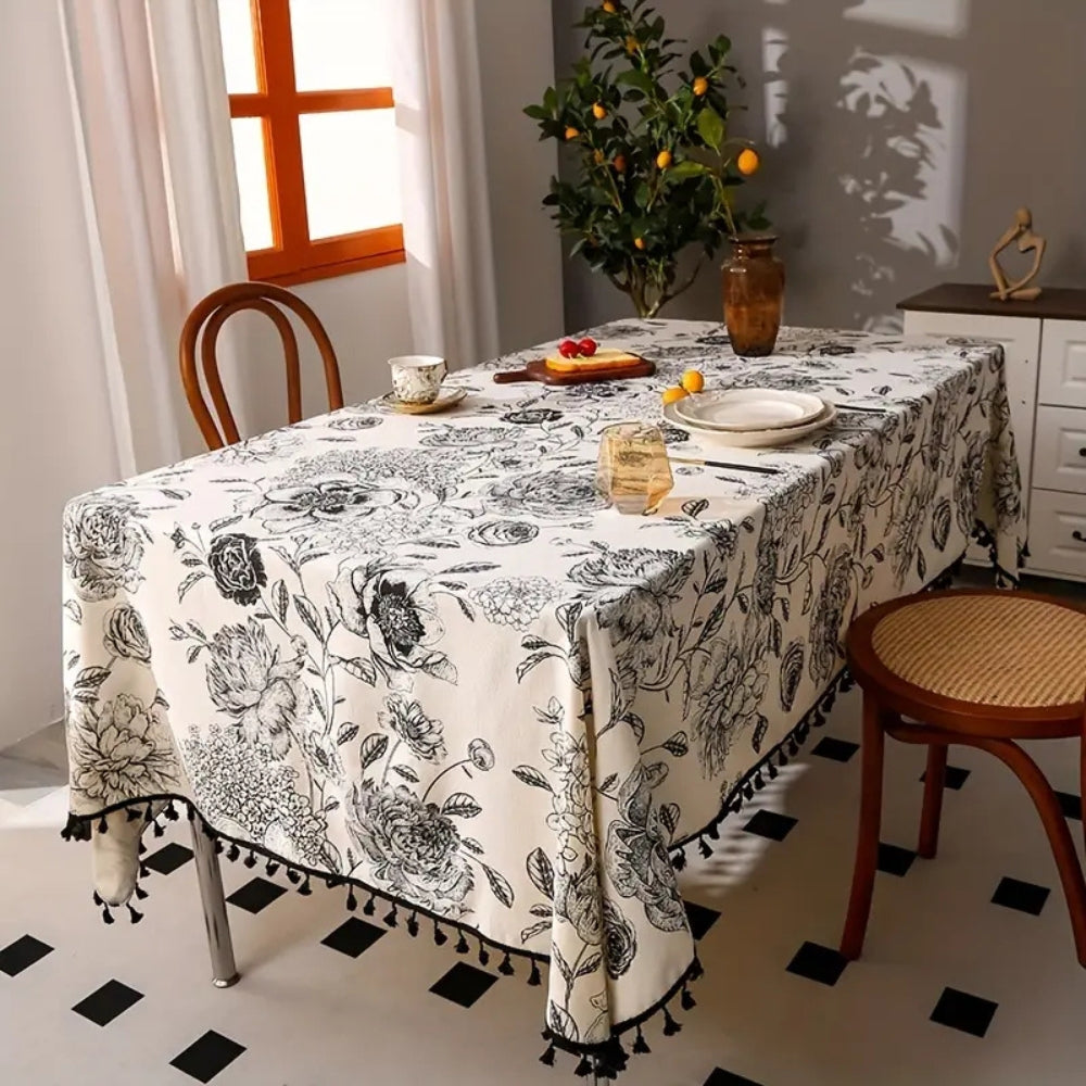 Black floral tasseled farmhouse tablecloth with a mix of lace and tassels, exuding a cozy farmhouse feel.
