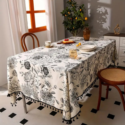 Black floral tasseled farmhouse tablecloth with a mix of lace and tassels, exuding a cozy farmhouse feel.
