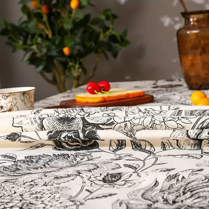 High-quality image of black floral tasseled farmhouse tablecloth with a beautiful floral pattern and tassels.