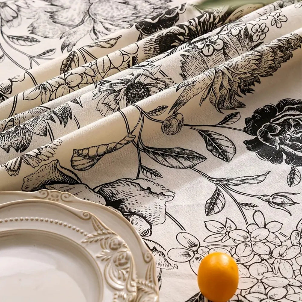 Black floral tasseled farmhouse tablecloth with a distressed look and a unique blend of lace and tassels.