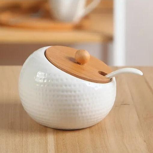 Front view of ceramic and wood sugar bowl with modern relief design