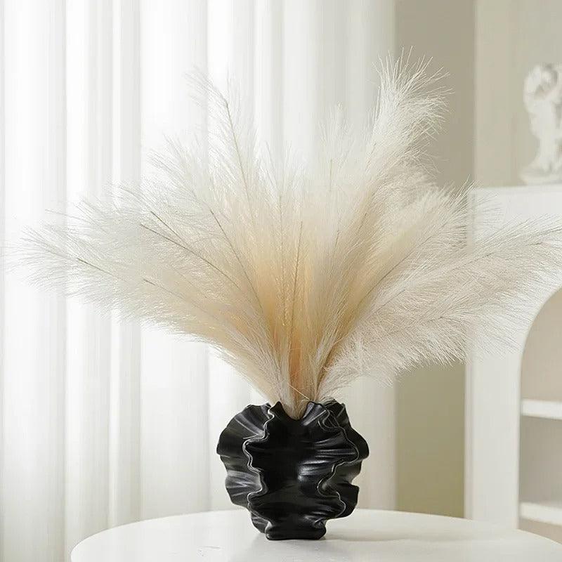 Side view of a minimalist coral vase made from ceramic, showcasing a cream matte finish.