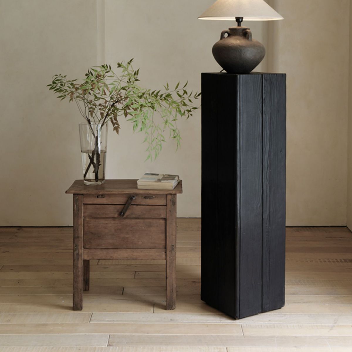 Charred wood pedestal base for displaying various home decor items